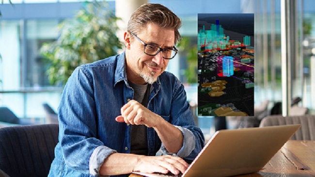 A man smiling while working on a computer